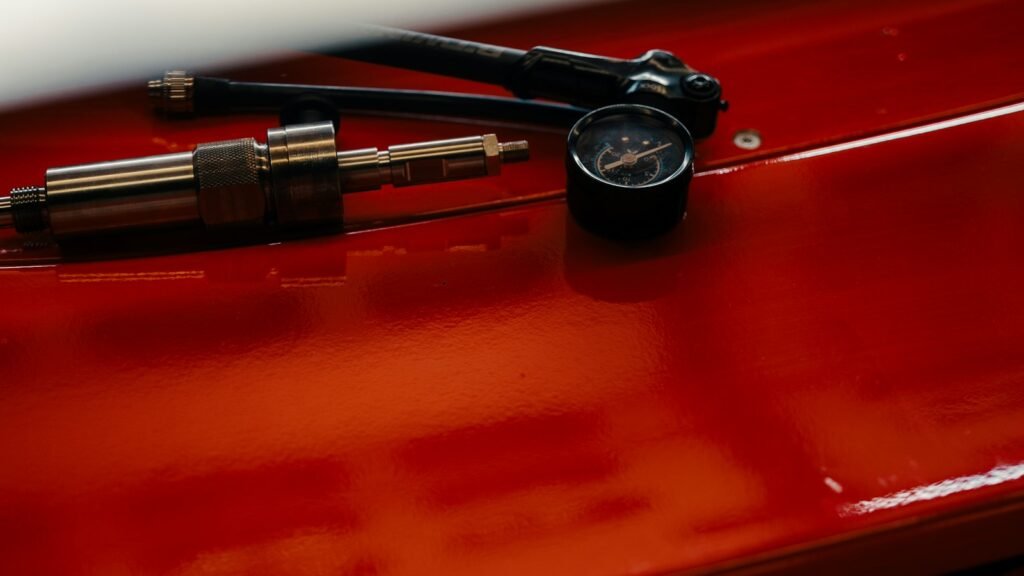 Manomètre et gonfleur de pneus sur une surface rouge