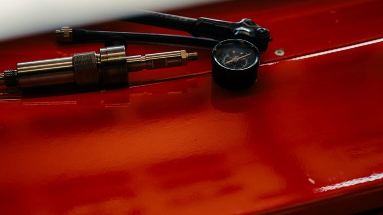 Manomètre et gonfleur de pneus sur une surface rouge