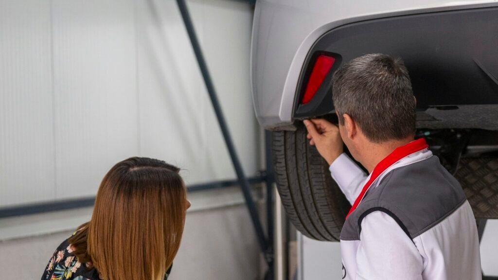 Un homme et une femme examinant le dessous d'une voiture