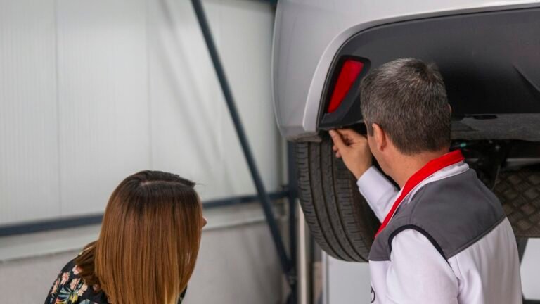 Un homme et une femme examinant le dessous d'une voiture