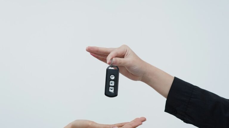 Mains échangeant une clé de voiture sur fond clair